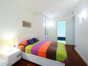 sypialnia z łóżkiem z kolorowym kocem w obiekcie Apartment Diagonal Mar by Interhome w Barcelonie