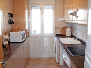 a small kitchen with a sink and a microwave at Apartment Turquesa by Interhome in Denia