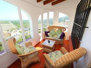 Monte PegoにあるHoliday Home Los Patios by Interhomeのバルコニー(籐の椅子、テーブル、窓付)