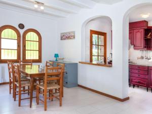 cocina con armarios rojos, mesa y sillas en Holiday Home Cabanyes by Interhome en Calonge