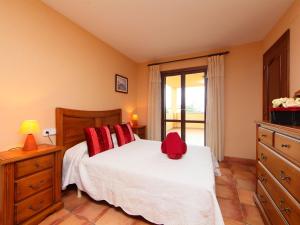una camera da letto con un letto con un cappello rosso sopra di Holiday Home Casa Ulldellops by Interhome a L'Ampolla