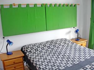 デニアにあるApartment Turquesa by Interhomeのベッドルーム1室(ベッド1台、上に緑のボード付)