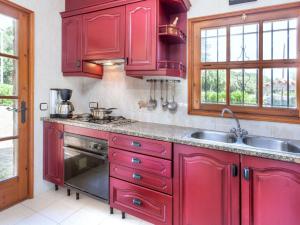 una cocina con armarios rojos y fregadero en Holiday Home Cabanyes by Interhome en Calonge