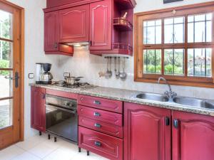 Una cocina con gabinetes rojos y un fregadero. en Holiday Home Cabanyes by Interhome, en Calonge