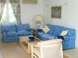 a living room with blue couches and a table at Apartment Club Sevilla I by Interhome in Casas Devesa