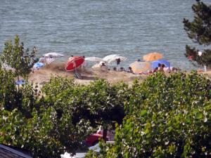 a group of people on a beach with umbrellas at Apartment Edificio Bahia II by Interhome in Miño