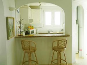 a kitchen with two bar stools and a sink at Apartment Club Sevilla I by Interhome in Casas Devesa