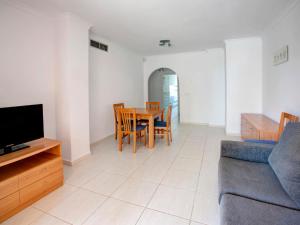 ein Wohnzimmer mit einem Tisch und einem Sofa in der Unterkunft Apartment Keops by Interhome in Casas Devesa