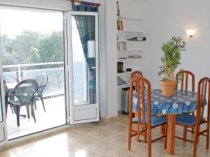 a dining room with a table and chairs and a balcony at Apartment Turquesa by Interhome in Denia