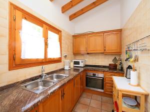 una cocina con armarios de madera y fregadero en Holiday Home Monte y Mar by Interhome, en Monte Pego