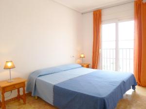 ein Schlafzimmer mit einem blauen Bett und einem großen Fenster in der Unterkunft Apartment Altea Dorada by Interhome in Altea la Vieja