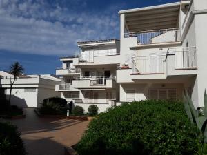 a white apartment building with balconies and a driveway at Residencia Platja de Roses in Roses