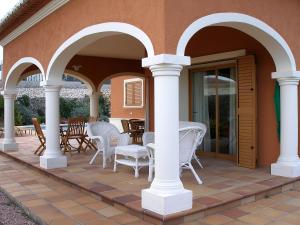an outdoor patio with white chairs and tables at Villa Corona by Interhome in Beniarbeig