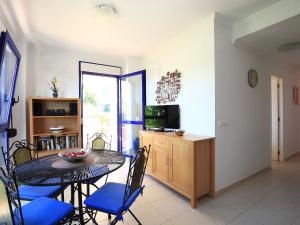 ein Esszimmer mit einem Tisch, Stühlen und einem TV in der Unterkunft Apartment Alma del Sol by Interhome in Denia