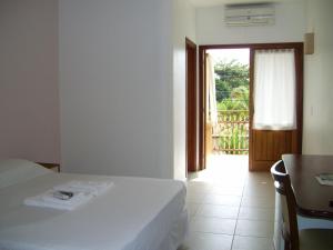 
a hotel room with a bed and a window at Pousada do Tié in Ubatuba
