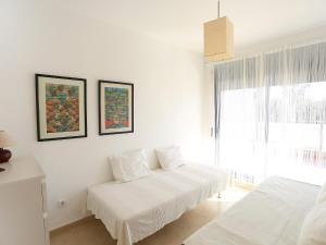 a white room with two beds and a window at Holiday Home Peiro by Interhome in L'Ampolla