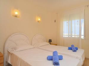 two beds in a bedroom with blue pillows on them at Apartment Golden Beach by Interhome in Jávea