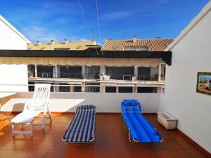 a balcony with two blue chairs and a table and chairs at Apartment San Esteban by Interhome in Jávea