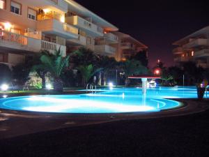 a swimming pool at night in front of a building at Apartment Nou Fontana-4 by Interhome in Jávea