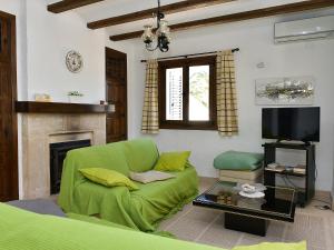 a living room with a green couch and a tv at Holiday Home Toscal by Interhome in Balcon del Mar