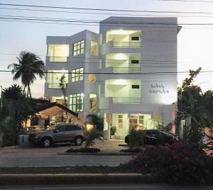 un edificio con un coche aparcado delante de él en Hotel Caribe, en Santa Cruz de Barahona