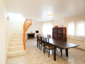 una sala da pranzo con tavolo, sedie e scala di Holiday Home Casa by Interhome a L'Ampolla
