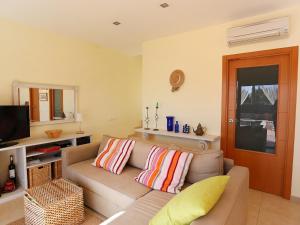 a living room with a couch and a television at Holiday Home Peiro by Interhome in L'Ampolla