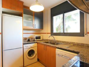 a kitchen with a white refrigerator and a dishwasher at Holiday Home Peiro by Interhome in L'Ampolla