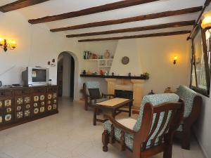 ein Wohnzimmer mit Stühlen, einem TV und einem Kamin in der Unterkunft Holiday Home Tosalans by Interhome in Balcon del Mar