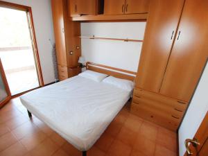 Dormitorio pequeño con cama y armario en Apartment Lecci-2 by Interhome en Eraclea Mare