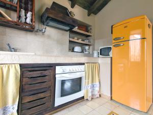 eine Küche mit einem Orangenkühlschrank und einem Herd in der Unterkunft Holiday Home Domi by Interhome in Zamorano