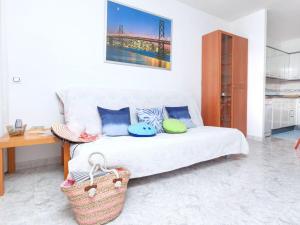 a living room with a white bed with a basket at Apartment Fleming by Interhome in Lloret de Mar