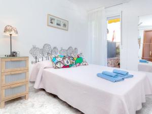 a white bedroom with two beds and a dresser at Apartment Fleming by Interhome in Lloret de Mar