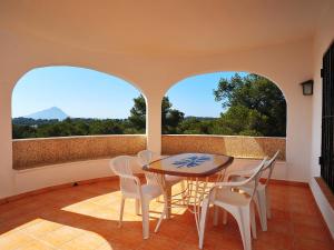 a dining room with a table and chairs and two windows at Holiday Home Balcon al Mar by Interhome in Balcon del Mar