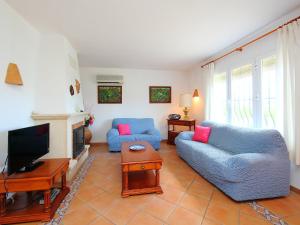 Monte PegoにあるHoliday Home Inma by Interhomeのリビングルーム(青いソファ2台、テレビ付)