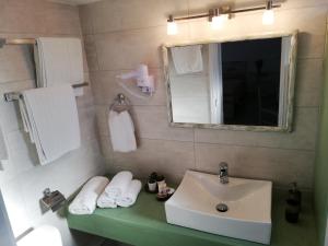 y baño con lavabo y espejo. en Meltemi Hotel Kythnos, en Loutra