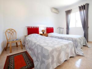 a bedroom with two beds and a chair in it at Villa Ingy by Interhome in Calpe