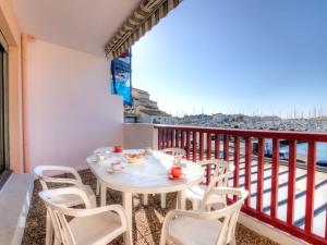 a table and chairs on a balcony with a view of the city at Apartment Le Grand Pavois by Interhome in Capbreton