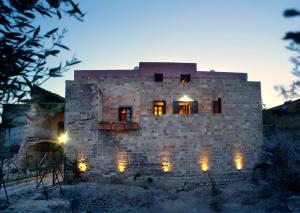 uma casa de pedra com luzes ao anoitecer em Mystic Hotel - Adults only in Ilha de Rhodes