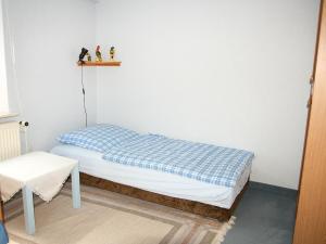 ein kleines Bett in einem Zimmer mit einem Regal an der Wand in der Unterkunft Apartment Kopei by Interhome in Eschenbruch