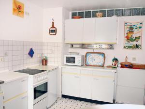 a kitchen with white cabinets and a microwave at Apartment Kopei by Interhome in Eschenbruch