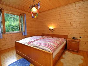 ein Schlafzimmer mit einem Bett in einem Blockhaus in der Unterkunft Chalet Haus Ahlfeld by Interhome in Sankt Aegyd am Neuwalde