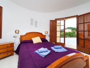 a bedroom with a purple bed with towels on it at Holiday Home Solenza by Interhome in Calonge