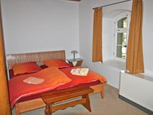 a bedroom with a bed with red sheets and a mirror at Apartment Kunstmühle by Interhome in Dienstedt-Hettstedt