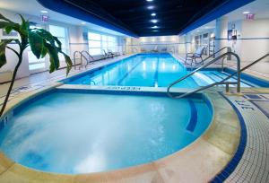 a large indoor swimming pool with blue water at The Penn Stater Hotel and Conference Center in State College