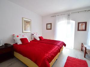 a bedroom with a bed with red sheets and a window at Apartment Andrea by Interhome in Opatija