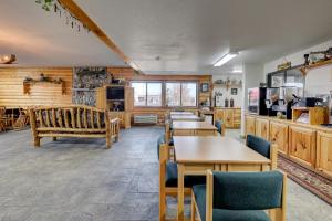 a restaurant with tables and chairs and a kitchen at Booneslick Lodge - Neosho in Neosho