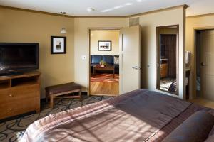 a bedroom with a bed and a flat screen tv at ClubHouse Hotel and Suites in Pierre