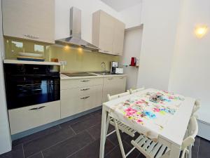 a kitchen with a white table and a stove top oven at Apartment Molo Lozna-2 by Interhome in Postira