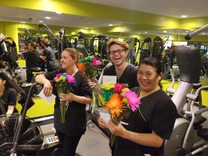 eine Gruppe von Menschen, die Blumen in einem Fitnessstudio halten in der Unterkunft Super 8 by Wyndham Winnipeg West in Winnipeg